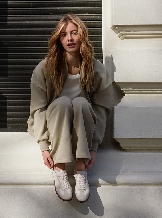 Model sitzt auf Fensterbrett mit Sweatsuit